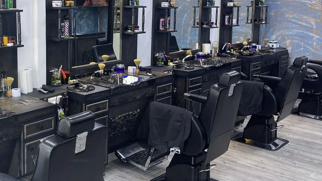 Black barber chairs and illuminated mirrors inside Brotherhood Barbers on Sharrow Vale Road